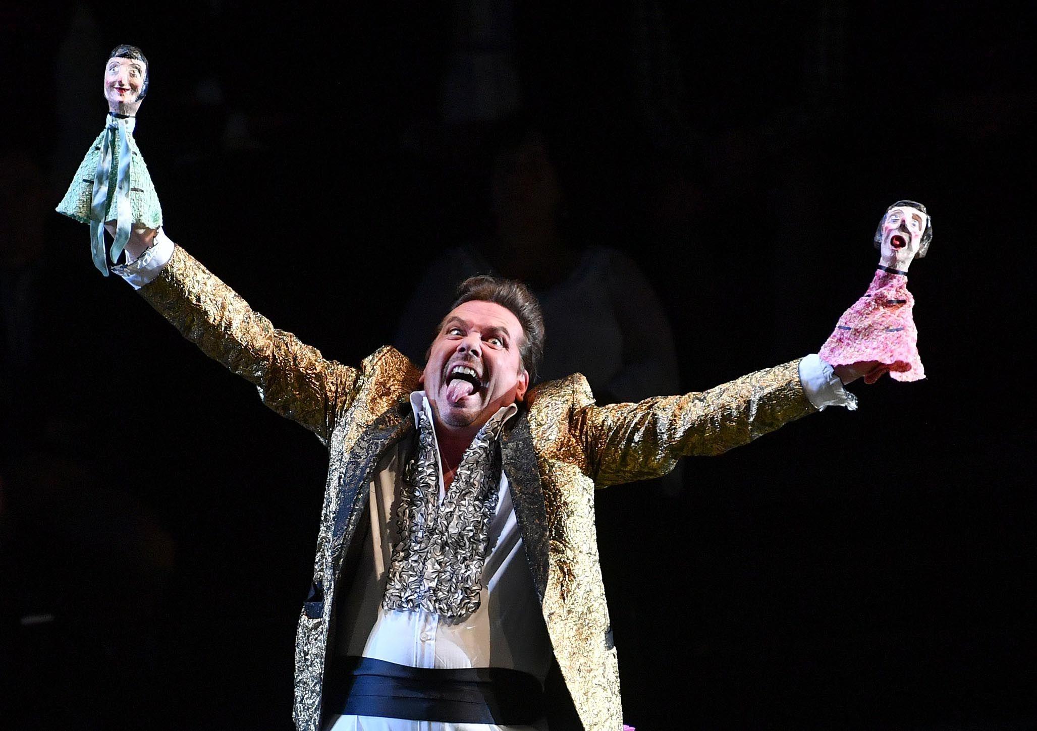 Der Schauspieler hält zwei Puppenfiguren bei den Salzburger Festspielen 2017