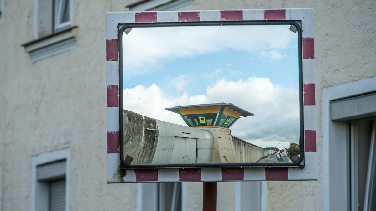 In einem Verkehrsspiegel spiegelt sich ein Wachturm der Justizvollzugsanstalt in Straubing