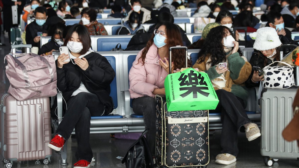 Reisen ist nach rigoroser Null-Covid-Strategie in China seit Anfang Dezember 2022 wieder möglich und die Folgen - wie hier im Bild - sichtbar. Die Aufnahme vom 12. Dezember 2022 zeigt Passagiere in einer Wartehalle eines Bahnhofs in Huaian. 