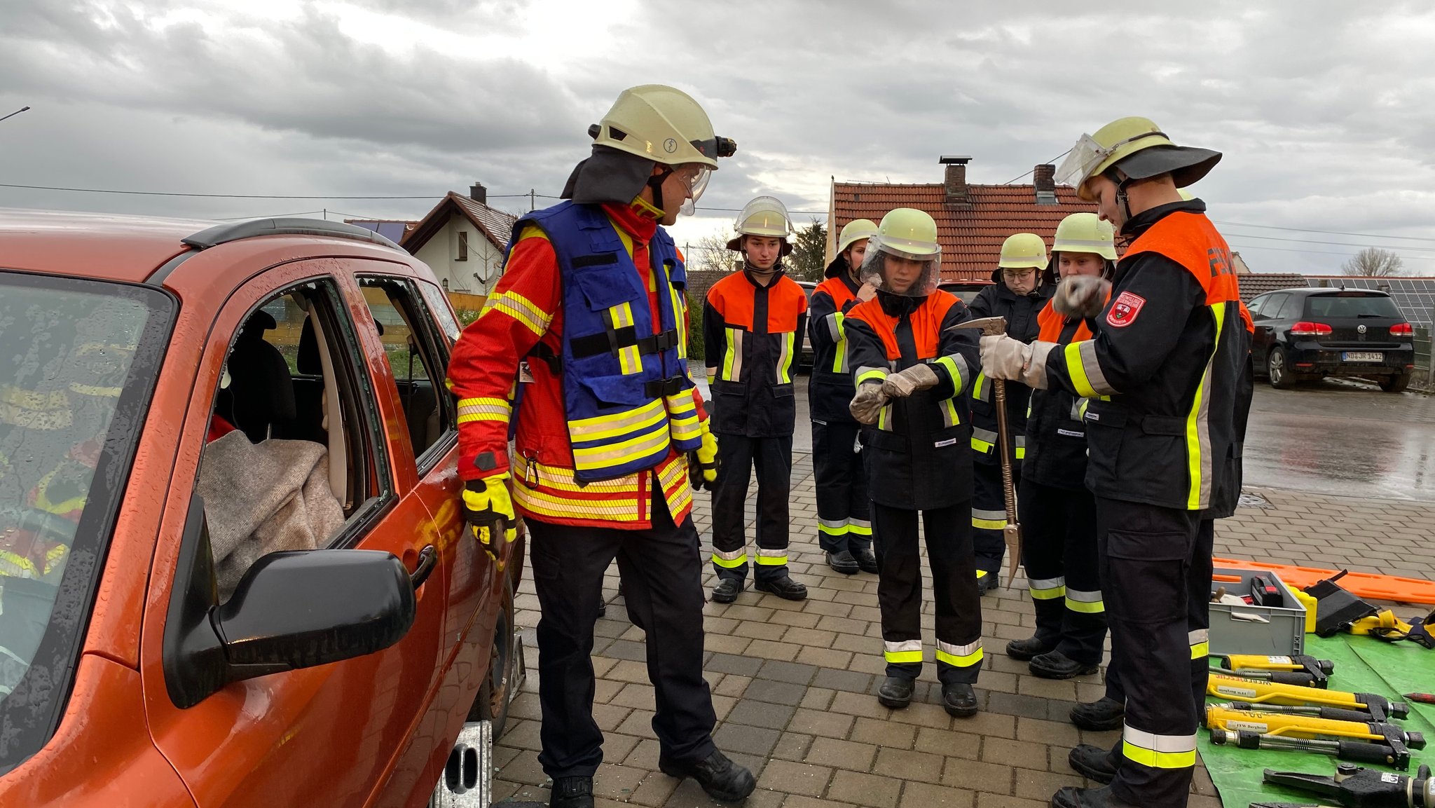 Feuerwehrleute vor einem Auto während einer Übung. 