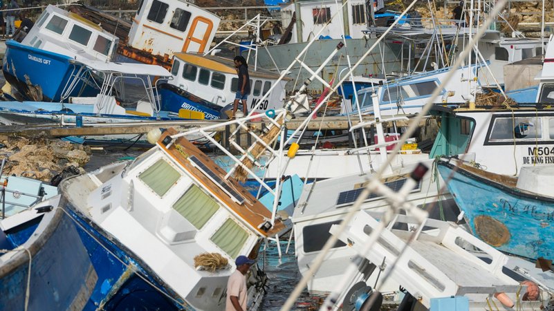 01.07.2024, Barbados, Bridgetown: Ein Mann betrachtet die vom Hurrikan "Beryl" beschädigten Fischerboote. 