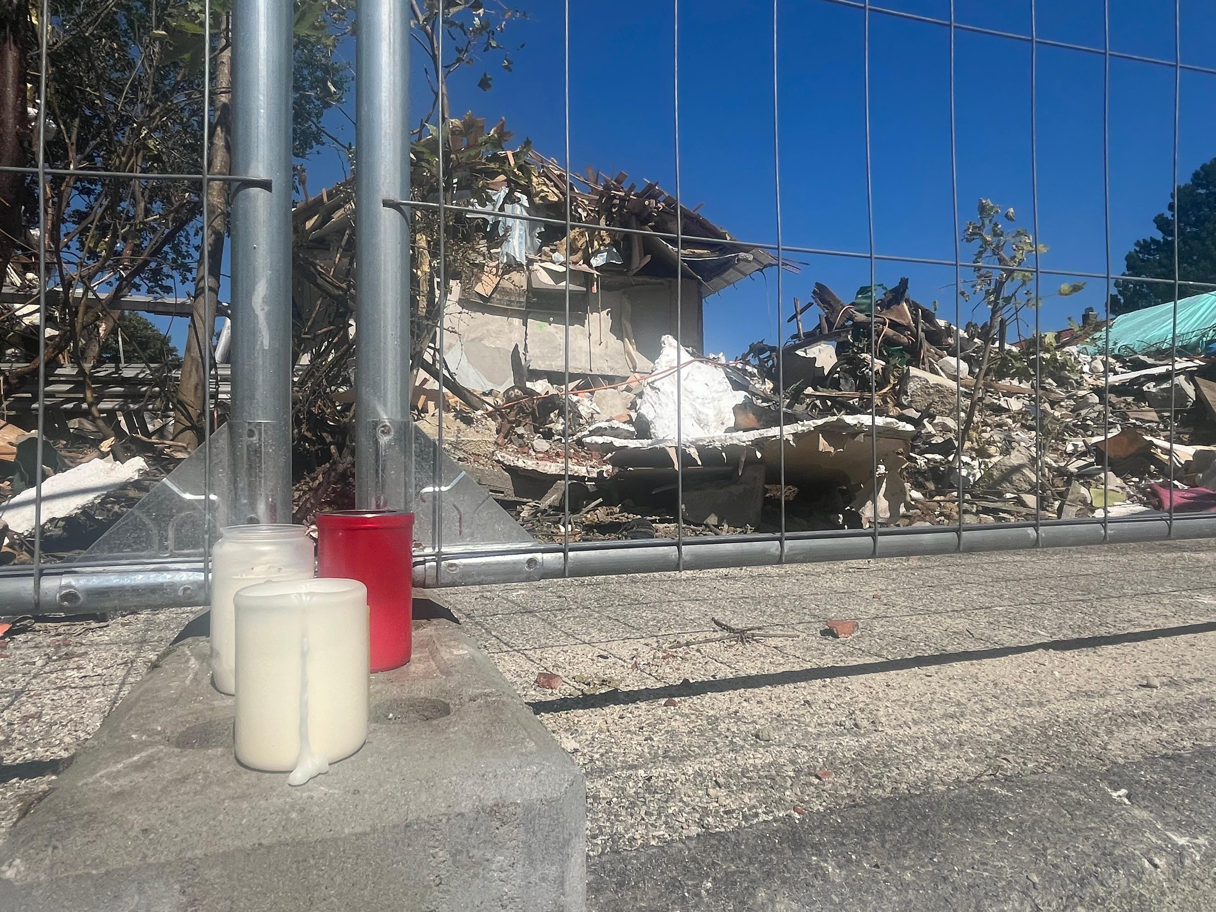 Drei Grablichter für den getöteten 17-Jährigen stehen an einem Bauzaun vor dem explodierten Haus in Memmingen. 