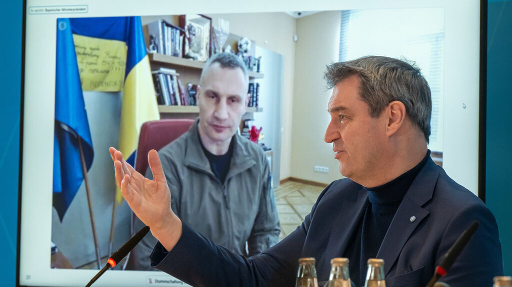 21.03.2023, Bayern, München: Vitali Klitschko (l), Bürgermeister der ukrainischen Hauptstadt Kiew, ist zu Beginn der Sitzung des bayerischen Kabinetts unter der Leitung von Markus Söder, (r, CSU) Ministerpräsident von Bayern, per Video zugeschaltet.  Bayerns Ministerpräsident Markus Söder (CSU) hat der Ukraine zusätzliche Hilfen versprochen und will den Kontakt zwischen dem Freistaat und der Ukraine intensivieren. Foto: Peter Kneffel/dpa +++ dpa-Bildfunk +++