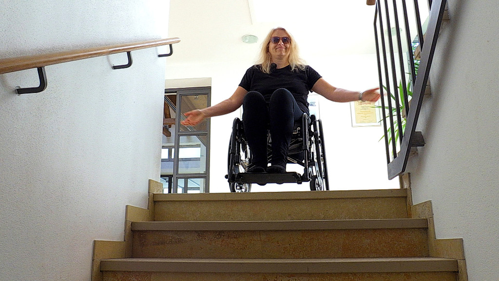 Kerstin Rathgeb im Rollstuhl an einem Treppenabsatz.