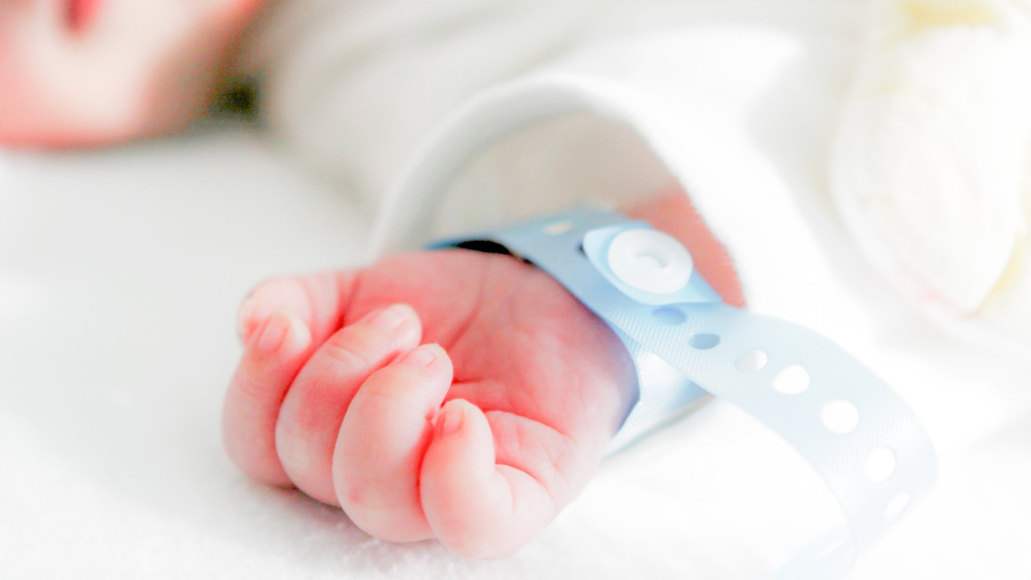 Die Hand eines neugeborenen Babys mit Namensbändchen am Handgelenk. | Bild: stock.adobe.com/Nenov Brothers Die Hand eines neugeborenen Babys mit Namensbändchen am Handgelenk.
