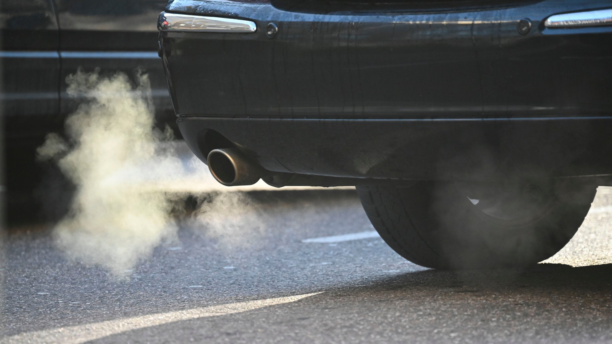 Weißer Rauch bläst aus dem Auspuff eines Kraftfahrzeugs im Straßenverkehr. | Bild: picture alliance/dpa | Katharina Kausche Weißer Rauch bläst aus dem Auspuff eines Kraftfahrzeugs im Straßenverkehr.