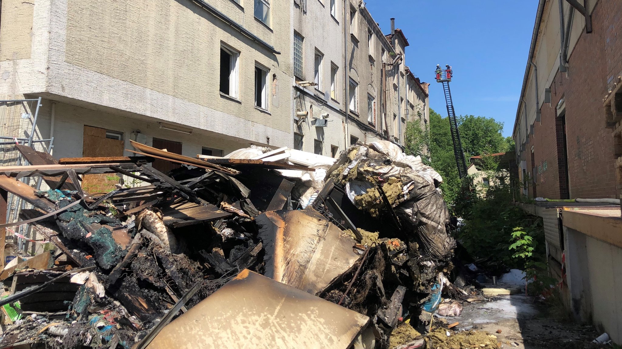 Nach dem Brand auf einem Kaufbeurer Brauereigelände: Verkohlte Gegenstände und die Drehleiter der Feuerwehr