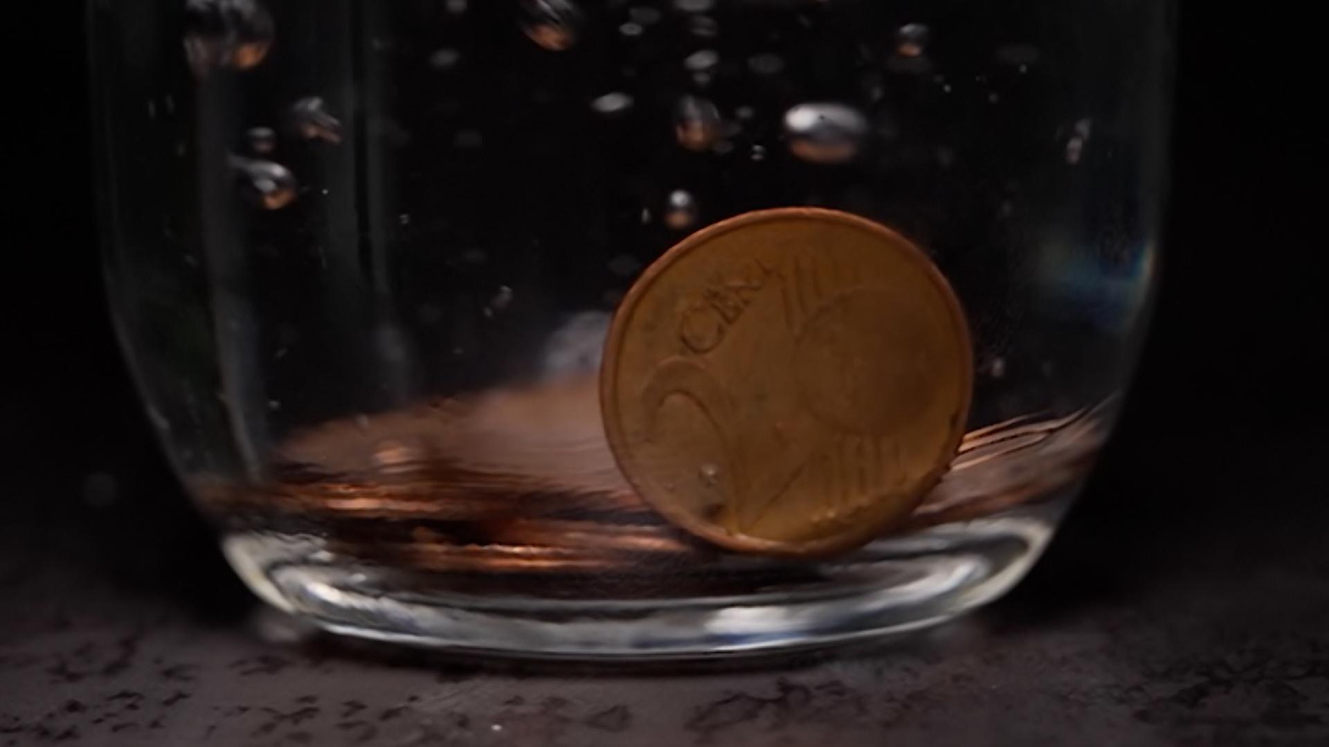 Eine 2-Cenz-Münze in einem Wasserglas