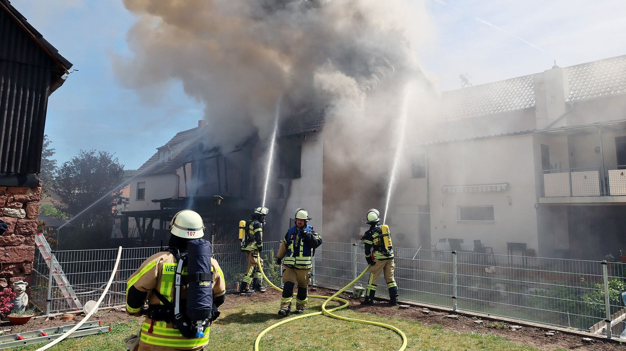 Feuerwehrleute löschen den Brand in einer Asylunterkunft in Unterfranken