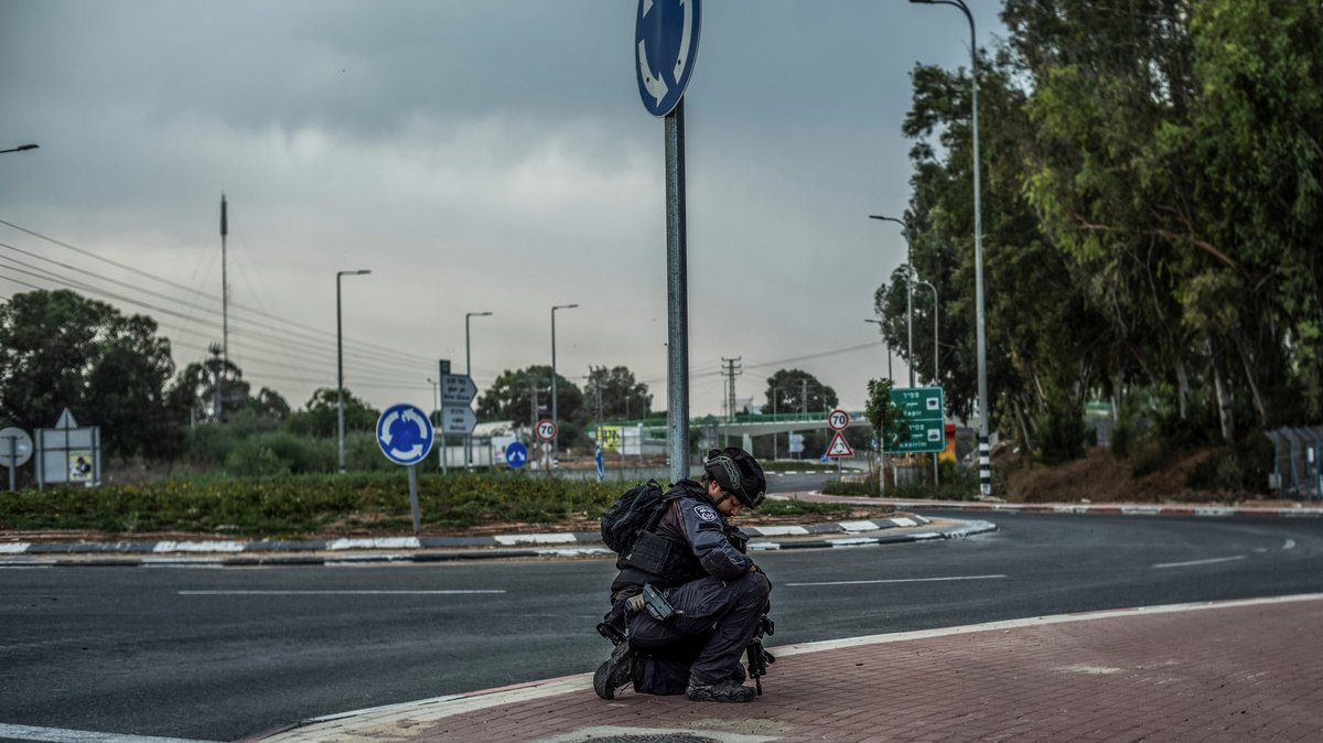 Ein israelischer Polizeibeamter kniet während der Suche nach Verdächtigen