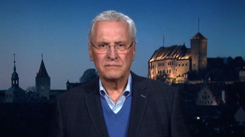 Bayerns Innenminister Joachim Herrmann vor einem nächtlichen Panorama Nürnbergs mit der beleuchteten Burg. | Bild: Bayerischer Rundfunk 2024 Bayerns Innenminister Joachim Herrmann vor einem nächtlichen Panorama Nürnbergs mit der beleuchteten Burg.