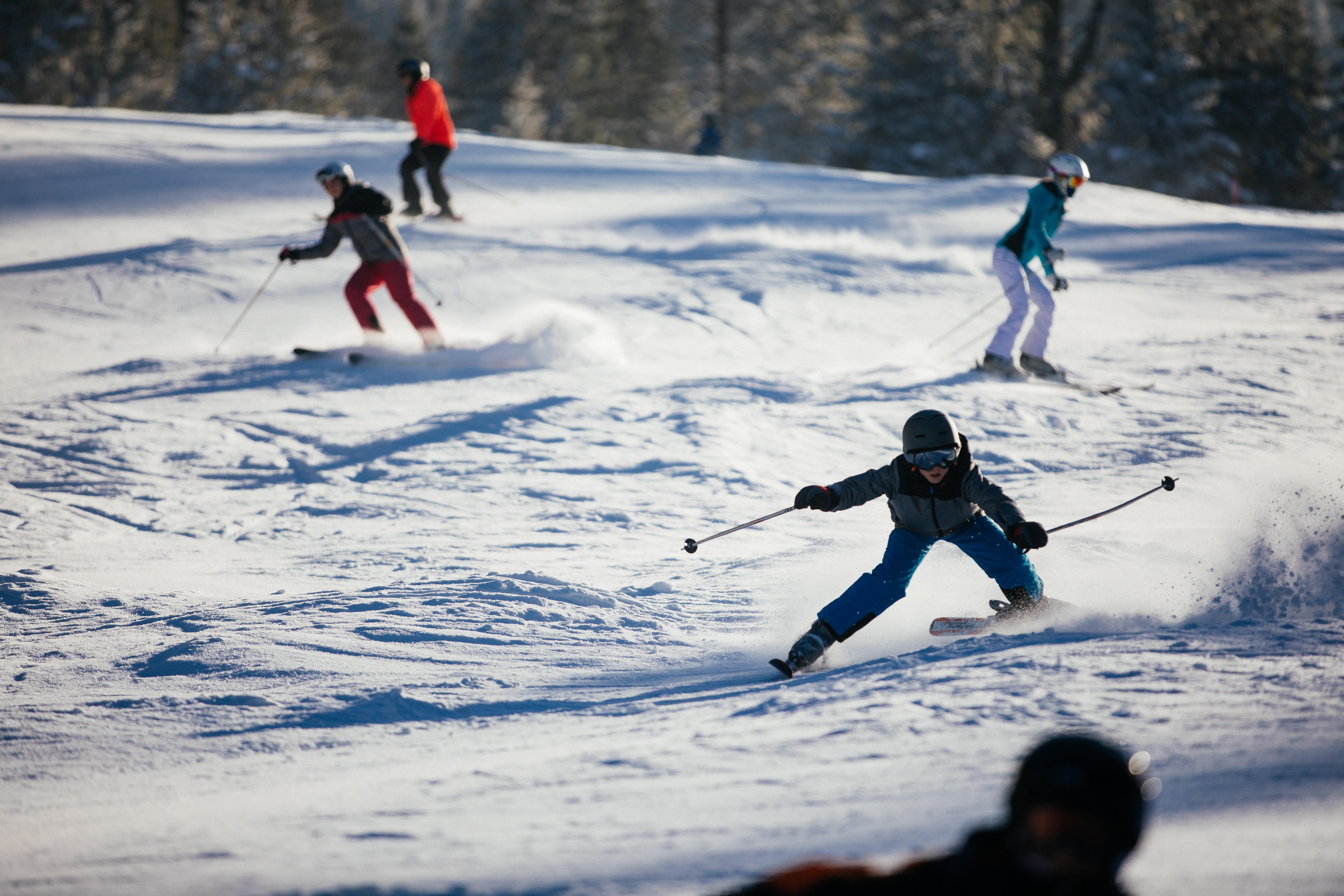 Kinder und Teenager auf einer Skipiste.