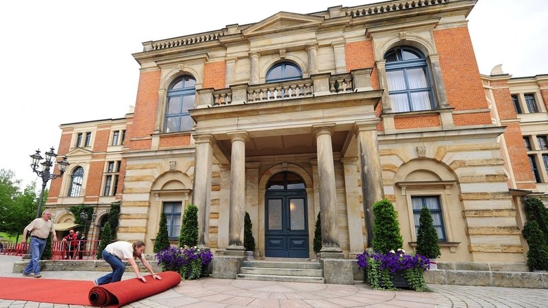 Vor dem Bayreuther Festspielhaus wird der rote Teppich ausgerollt. | Bild: picture alliance/dpa Vor dem Bayreuther Festspielhaus wird der rote Teppich ausgerollt.