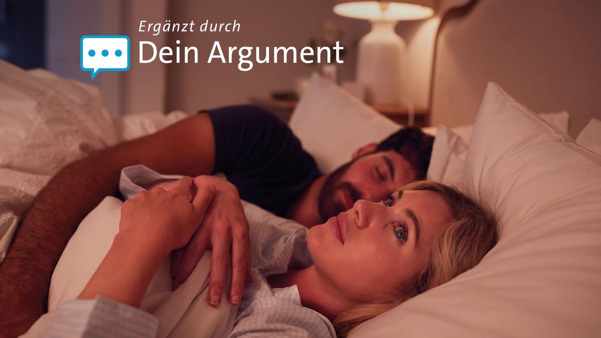 Ein heterosexuelles Paar liegt im Bett. Der Mann schläft, die Frau liegt wach und schaut zur Decke.