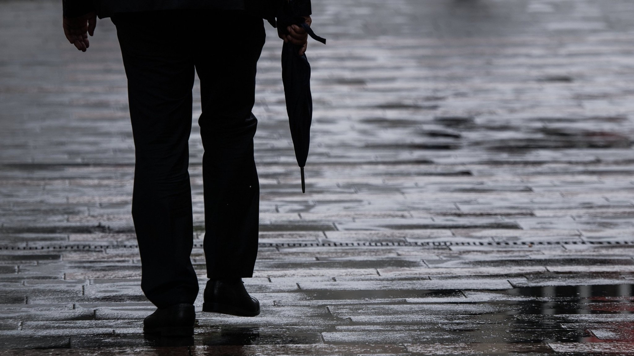 ARCHIV - 13.08.2018, Rheinland-Pfalz, Mainz: Ein Passant geht mit einem Regenschirm in der Hand durch die Mainzer Fußgängerzone. (zu dpa: «Regen und einzelne Gewitter erwartet») Foto: Andreas Arnold/dpa +++ dpa-Bildfunk +++