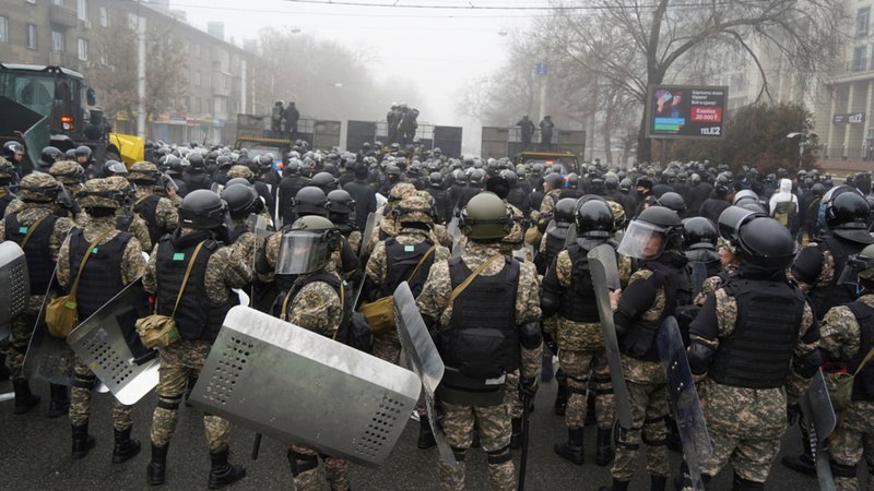 Bereitschaftspolizisten blockieren eine Straße in Almaty in Kasachstan, um Demonstranten aufzuhalten.
