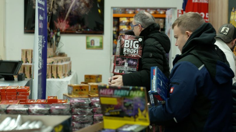 Kunden tragen große Pakete mit Feuerwerkskörper aus einem Geschäft. | Bild: BR Kunden tragen große Pakete mit Feuerwerkskörper aus einem Geschäft.