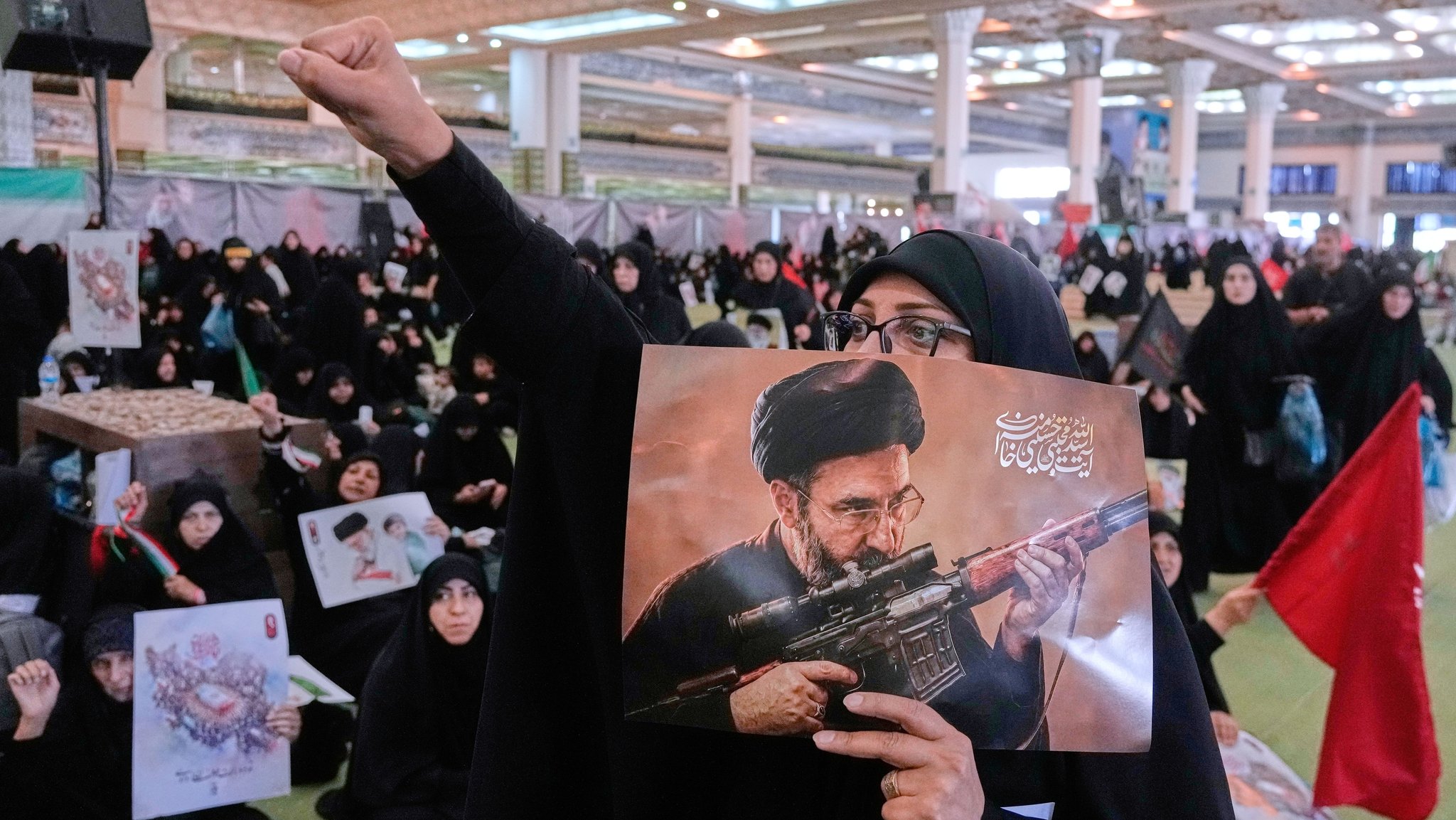 ARCHIV - 14.07.2026, Iran, Teheran: Eine Frau hält ein Plakat des iranischen Obersten Führers Ajatollah Modschtaba Chamenei bei einer Gedenkfeier für den verstorbenen iranischen Obersten Führers Chamenei in der Großmoschee "Imam-Khomeini-Mosalla". | Bild: dpa-Bildfunk/Vahid Salemi ARCHIV - 14.07.2026, Iran, Teheran: Eine Frau hält ein Plakat des iranischen Obersten Führers Ajatollah Modschtaba Chamenei bei einer Gedenkfeier für den verstorbenen iranischen Obersten Führers Chamenei in der Großmoschee "Imam-Khomeini-Mosalla".