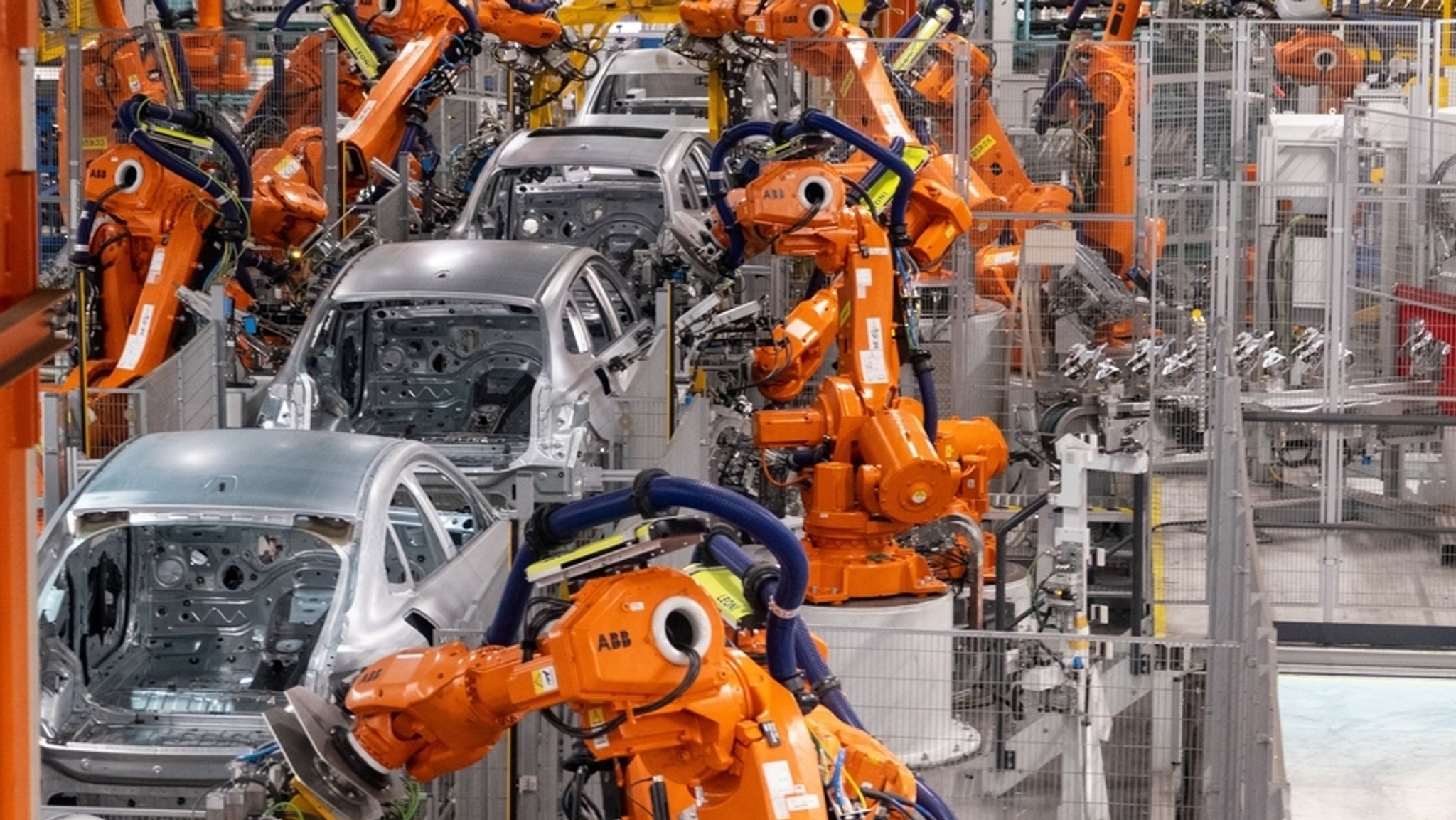 Automatisierte Produktion in einer Fahrzeugfabrik. Maschinen bearbeiten Autokarrosserien.