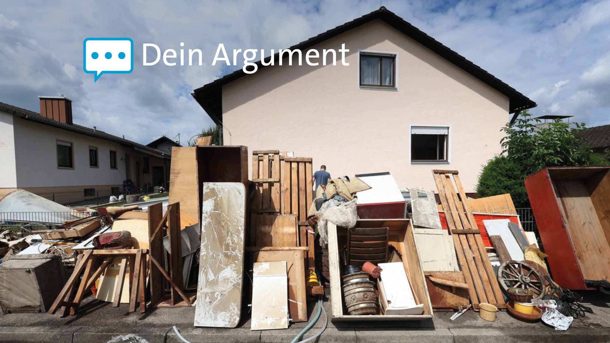 Vom Hochwasser zerstörte Gegenstände stehen vor einem Wohnhaus zum Abtransport bereit.