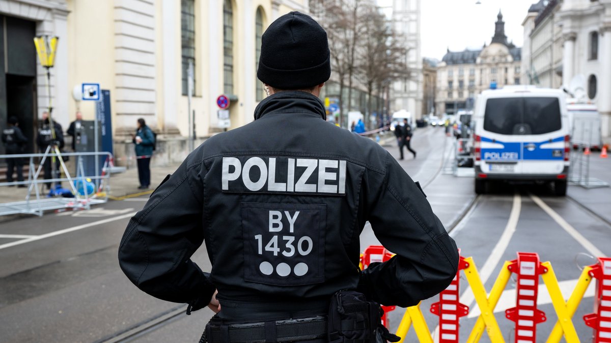 Ein Polizist steht hinter einer Straßenabsperrung zur Münchner Sicherheitskonferenz.