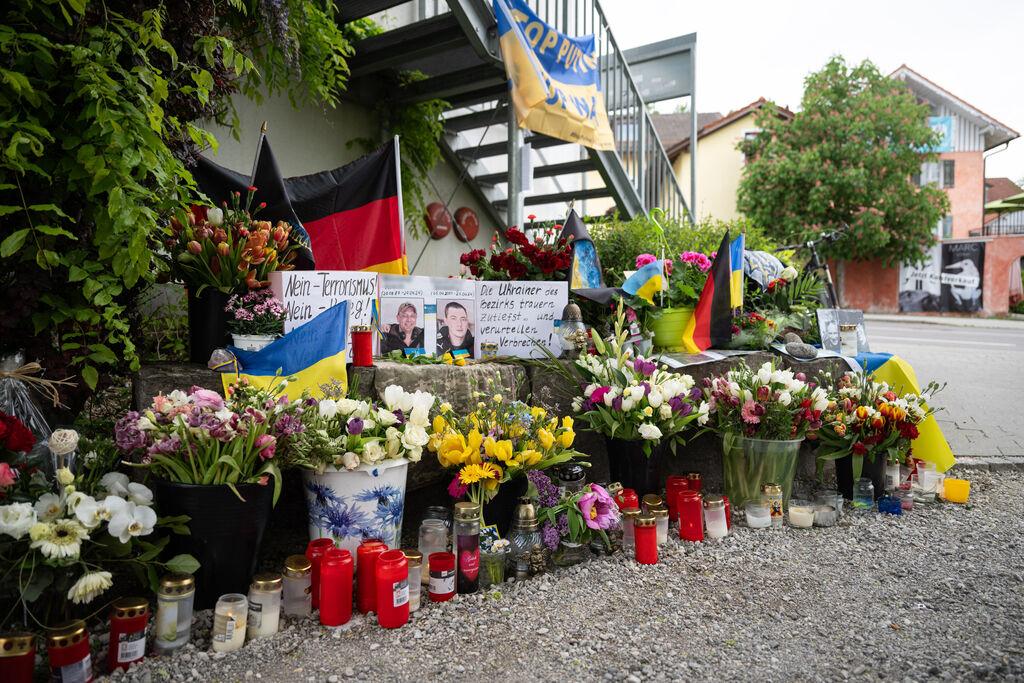 ARCHIV - 02.05.2024, Bayern, Murnau: Neben dem Einkaufszentrum an dem am 27.04.2024 zwei Männer aus der Ukraine getötet worden sind, wurden Blumen niedergelegt. Die beiden ukrainischen Soldaten im Alter von 23 und 36 Jahren waren zur medizinischen Behandlung und Rehabilitation in der Region. (zu dpa: «Zwei Ukrainer in Murnau getötet - Ermittler suchen wichtige Zeugin») Foto: Lukas Barth/dpa +++ dpa-Bildfunk +++