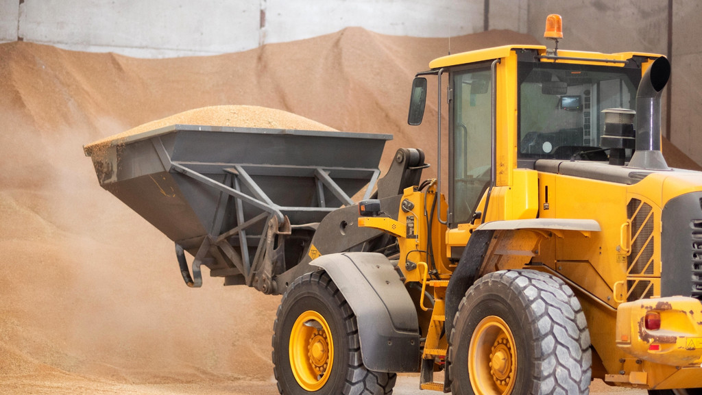 Symbolbild: Ein Bagger in einer Lagerhalle schaufelt Getreide. Weizen aus der Ukraine überschwemmt aktuell die Getreidemärkte in Polen | Bild: picture alliance / Zoonar | DAVID HERRAEZ CALZADA Symbolbild: Ein Bagger in einer Lagerhalle schaufelt Getreide. Weizen aus der Ukraine überschwemmt aktuell die Getreidemärkte in Polen