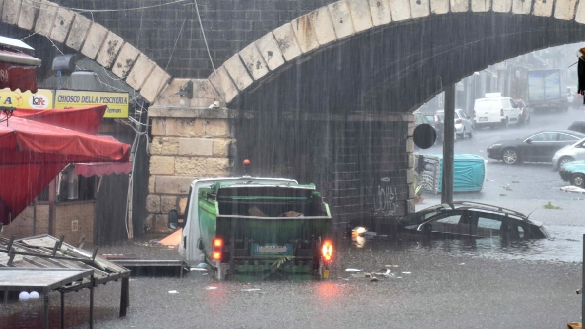 Fahrzeuge stehen auf einer überschwemmten Straße in Catania (Sizilien).