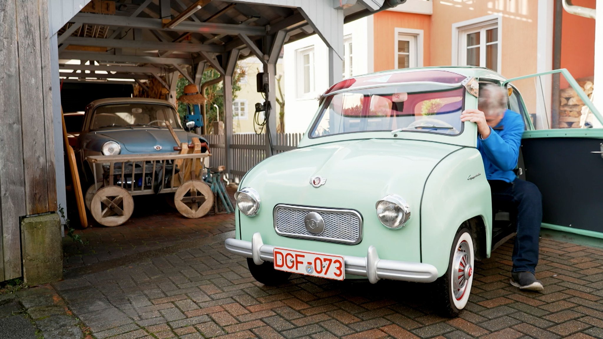 Mann steigt aus Goggomobil aus