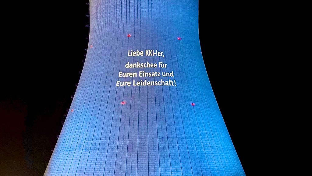 An einen Kühlturm des Atomkraftwerks Isar werden Botschaften projiziert.