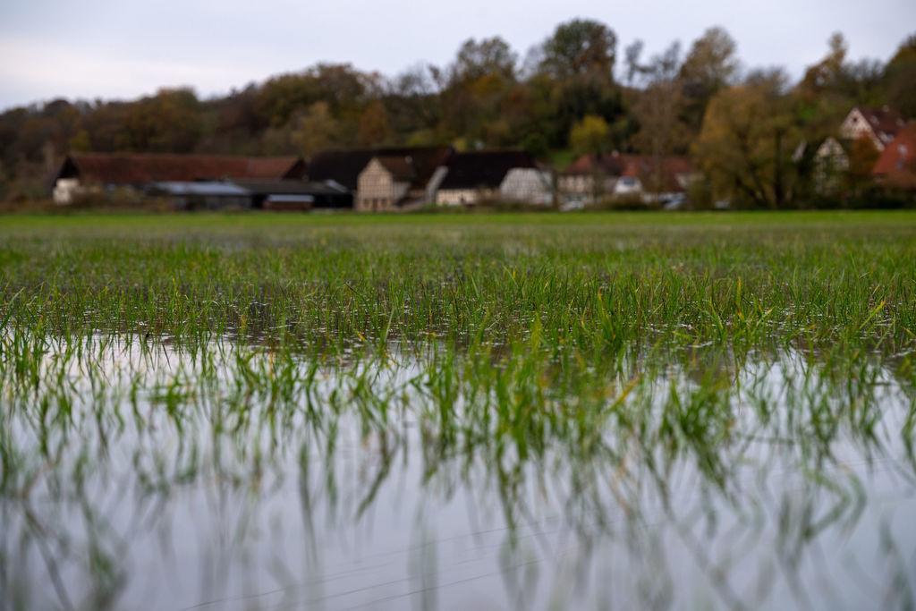 14.11.2023, Bayern, Hemmendorf: Wiesen vor einem Dorf sind überschwemmt. Bei Hemmendorf im Landkreis Haßberge in Unterfranken ist die Itz über die Ufer getreten. In den nächsten Tagen wird mit weiteren Niederschlägen gerechnet, wodurch das Hochwasser steigen könnte. Foto: Pia Bayer/dpa +++ dpa-Bildfunk +++