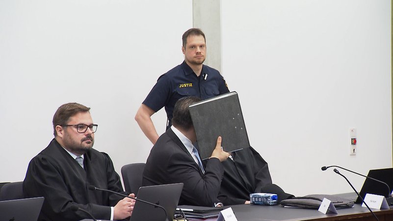 Der wegen Mordes angeklagte Mann (m) unterhält sich zu Prozessbeginn im Sitzungssaal im Landgericht Nürnberg-Fürth mit seinem Anwalt.