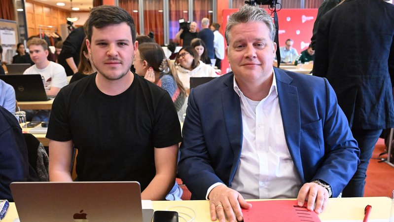 Der Vorsitzende Der Jusos Bayern, Benedict Lang (l) und der Landesgruppenvorsitzende Carsten Träger sitzen in der Landeskonferenz der Jusos Bayern. | Bild: picture alliance/dpa | Felix Hörhager Der Vorsitzende Der Jusos Bayern, Benedict Lang (l) und der Landesgruppenvorsitzende Carsten Träger sitzen in der Landeskonferenz der Jusos Bayern.