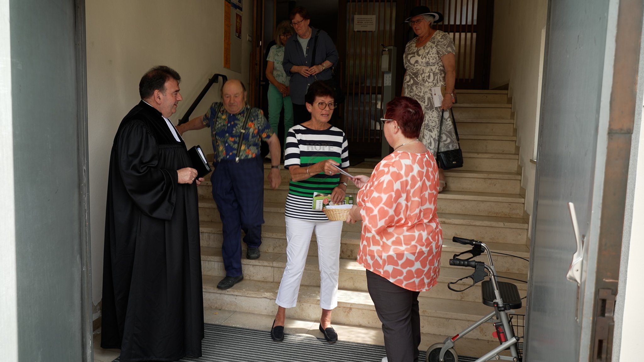 Kirchenbesucher erhalten nach dem Gottesdienst Umschläge mit zehn Euro an der Eingangstür der Christuskirche Donauwörth.