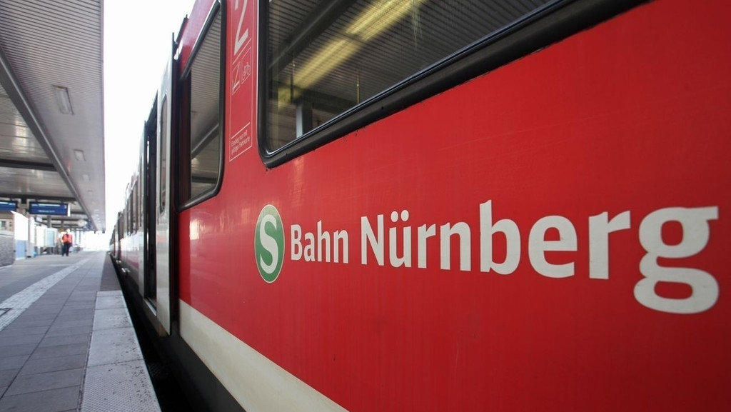 Ein roter Zug mit der Aufschrift "S-Bahn Nürnberg" steht an einem Bahnsteig. 