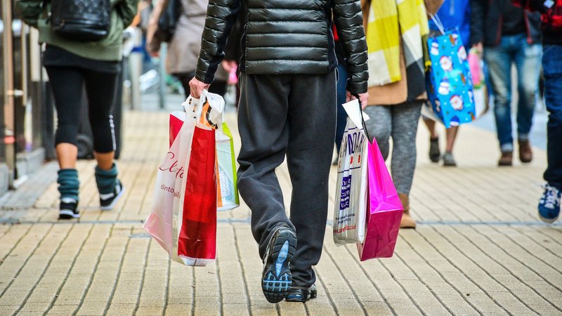 Einkäufer trägt Einkaufstaschen durch die Shopping-Mall. | Bild: picture alliance / empics | Ben Birchall Einkäufer trägt Einkaufstaschen durch die Shopping-Mall.