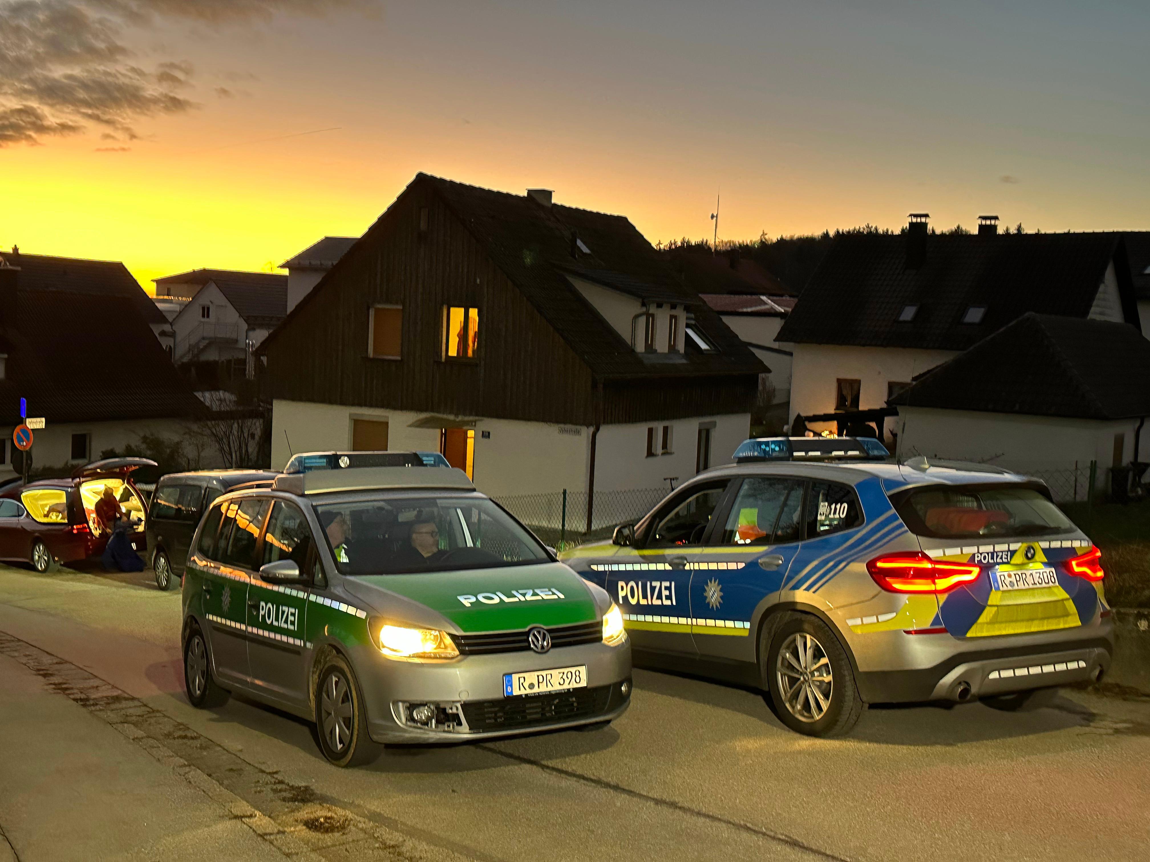 Vor dem Haus, in dem wohl eine Frau und ein Mann gewaltsam gestorben sind, stehen Polizeiautos.