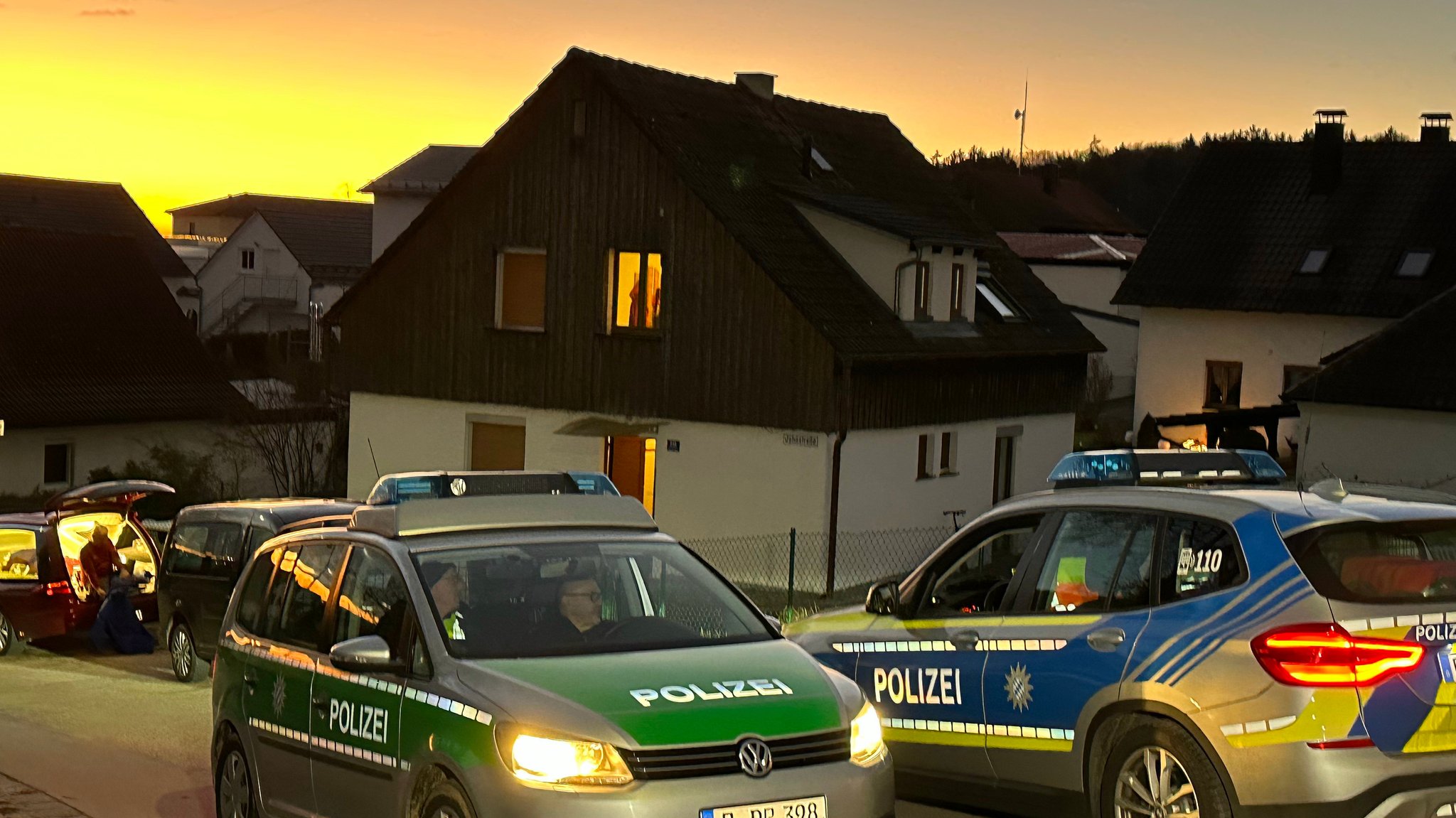 Vor dem Haus, in dem wohl eine Frau und ein Mann gewaltsam gestorben sind, stehen Polizeiautos.