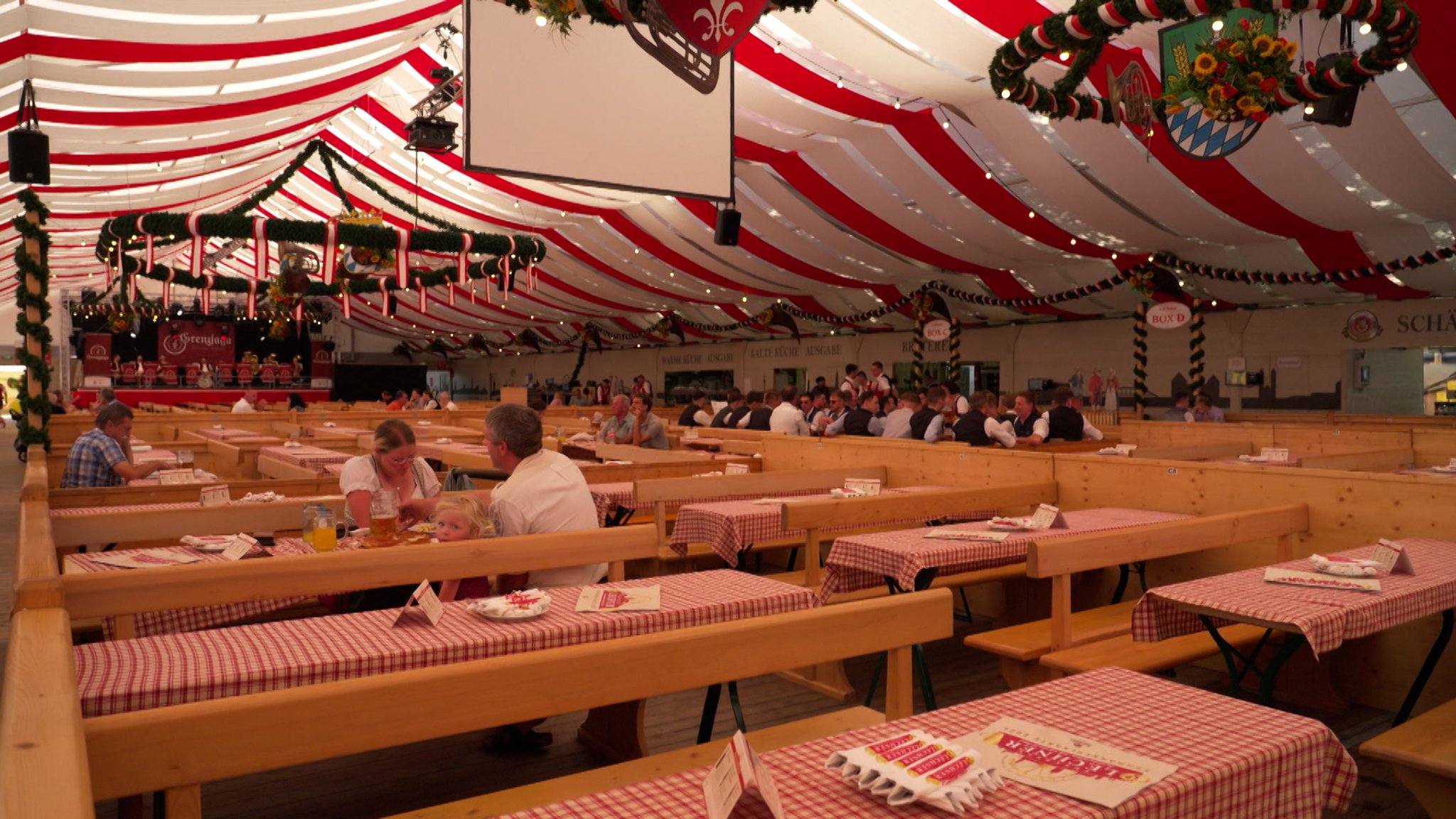 Einige Besucher sitzen zur Mittagszeit in einem Festzelt auf dem Gäubodenfest