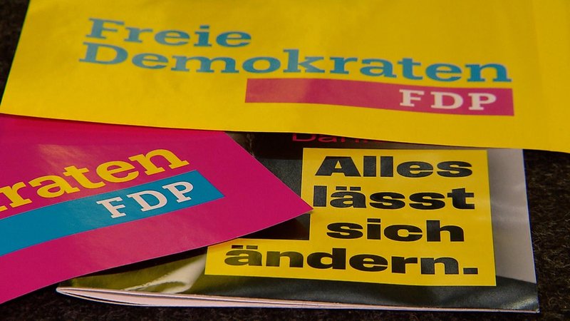 Nahaufnahme von Papieren mit FDP-Wahlsprüchen wie "Alles lässt sich ändern" und dem Logo der Partei. Die FDP Bayern zieht mit Martin Hagen an der Spitze in den Wahlkampf. | Bild: Bayerischer Rundfunk 2024 Nahaufnahme von Papieren mit FDP-Wahlsprüchen wie "Alles lässt sich ändern" und dem Logo der Partei. Die FDP Bayern zieht mit Martin Hagen an der Spitze in den Wahlkampf.