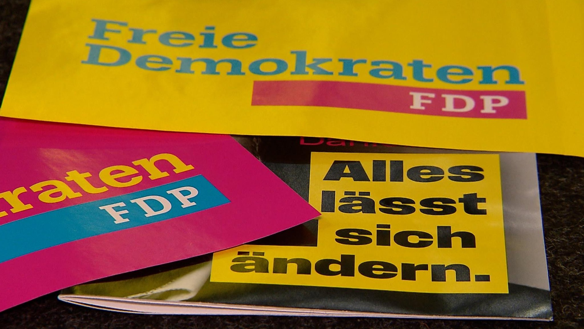 Nahaufnahme von Papieren mit FDP-Wahlsprüchen wie "Alles lässt sich ändern" und dem Logo der Partei. Die FDP Bayern zieht mit Martin Hagen an der Spitze in den Wahlkampf.