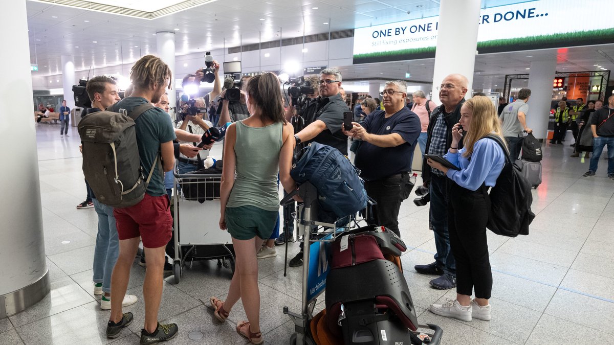 Israel-Reisende stehen nach ihrer Ankunft in der Empfangshalle des Münchner Flughafens.