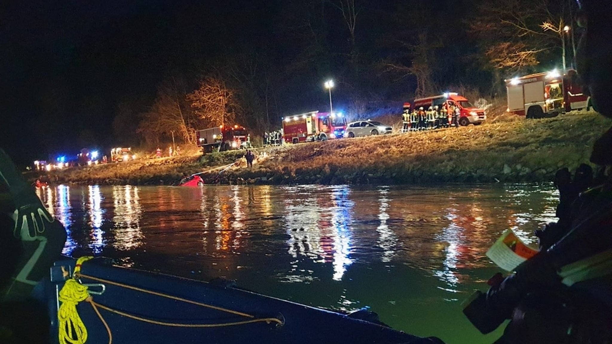 Einsatzkräfte der Wasserrettung bei der Bergung des Unglücksautos an der Salzach. 