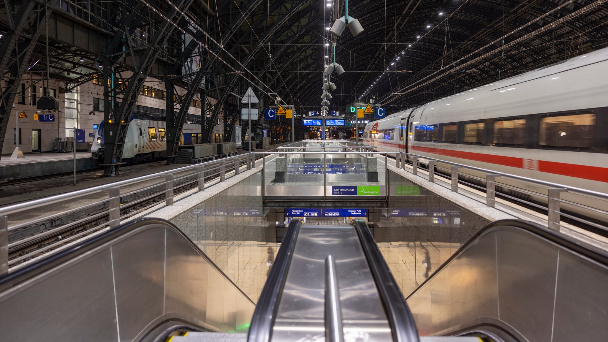 Rolltreppe am Bahnsteig mit einem Zug