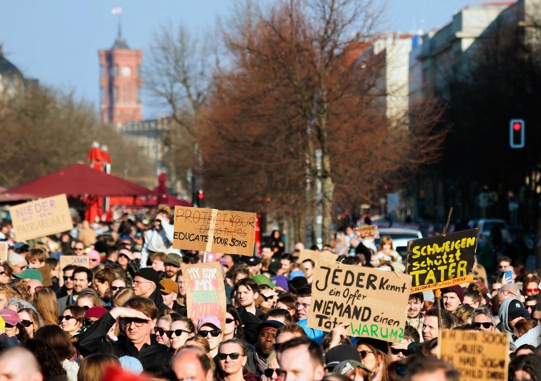 Schilder mit der Aufschrift "Jeder kennt ein Opfer - Niemand einen Täter Warum?" und "Schweigen schützt Täter" sind bei einer Demonstration gegen sexualisierte digitale Gewalt zu sehen.
