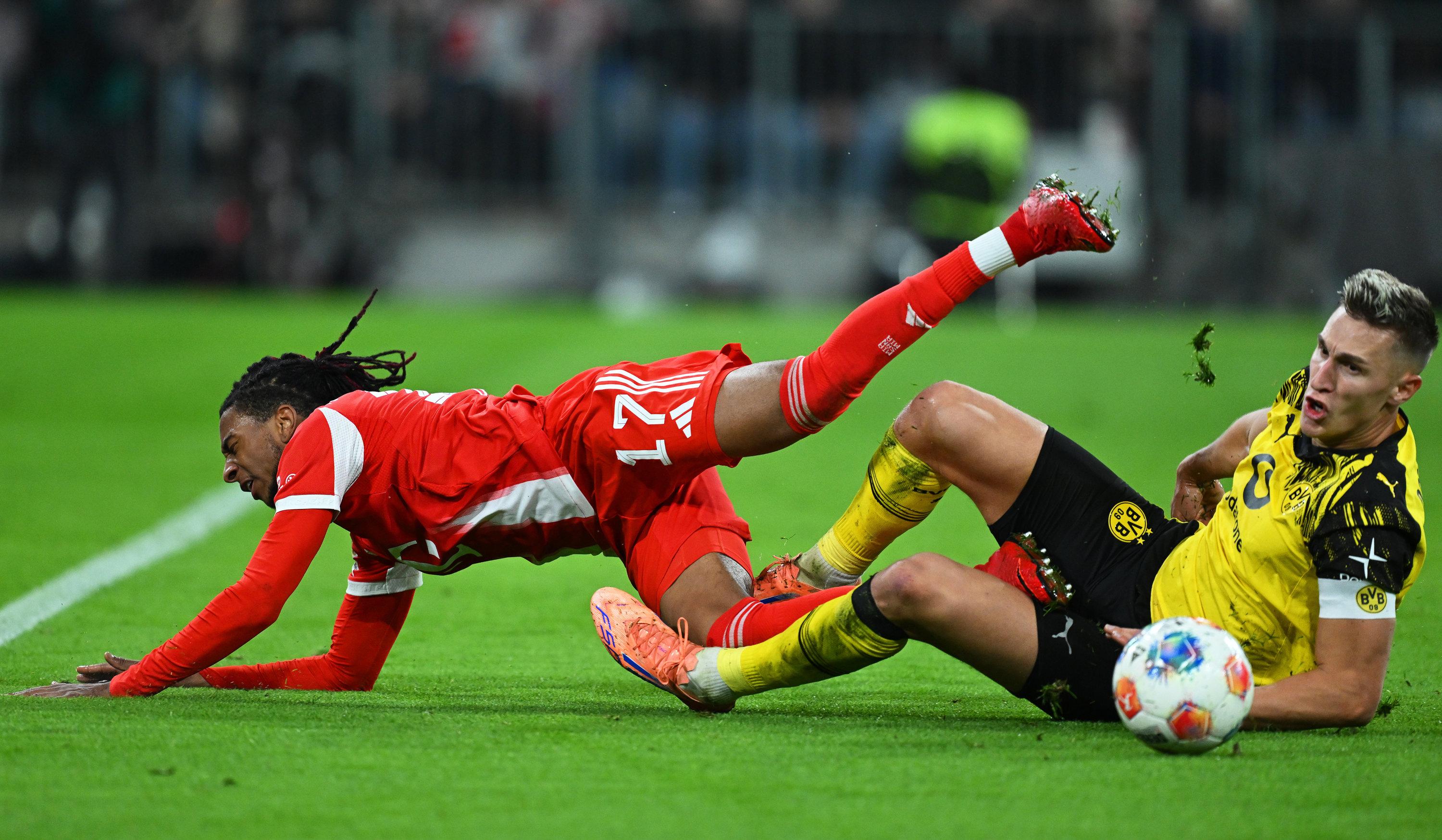 18.10.2025, Bayern, München: Fußball: Bundesliga, Bayern München - Borussia Dortmund, 7. Spieltag, Allianz Arena, Nico Schlotterbeck (r, Borussia Dortmund) grätscht gegen Michael Olise (Bayern München). 