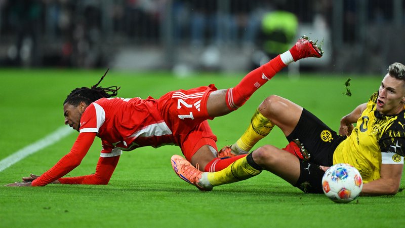 18.10.2025, Bayern, München: Fußball: Bundesliga, Bayern München - Borussia Dortmund, 7. Spieltag, Allianz Arena, Nico Schlotterbeck (r, Borussia Dortmund) grätscht gegen Michael Olise (Bayern München). | Bild: dpa-Bildfunk/Sven Hoppe 18.10.2025, Bayern, München: Fußball: Bundesliga, Bayern München - Borussia Dortmund, 7. Spieltag, Allianz Arena, Nico Schlotterbeck (r, Borussia Dortmund) grätscht gegen Michael Olise (Bayern München).