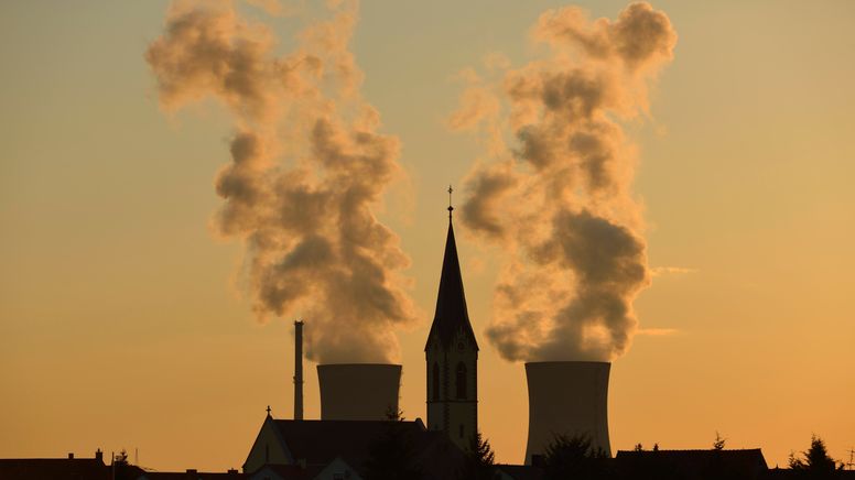 Manches hat sich in Sachen Klimaneutralität schon getan in Bayern: Die Kirche von Röthlein vor dem ehemaligen Kernkraftwerk Grafenrheinfeld, das 2015 stillgelegt wurde (Archivbild)  | Bild:picture alliance / imageBROKER | Lilly