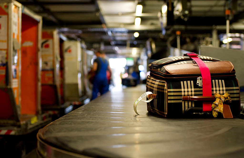 Zu sehen ist ein Koffer auf einem Gepäckband (Symbolbild). 