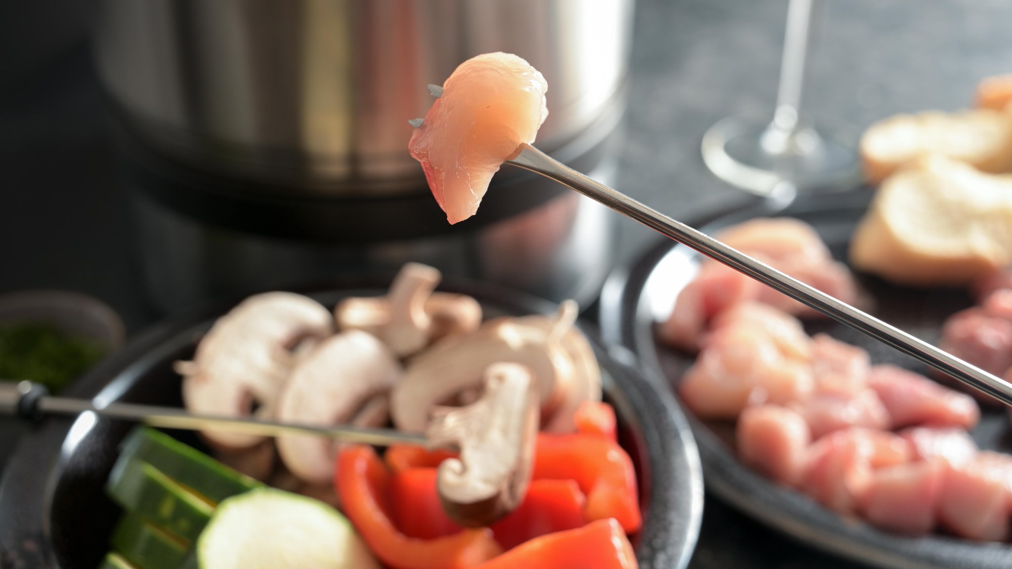 Ein Stück rohes Fleisch auf einem Fondue-Spieß (Symbolbild)